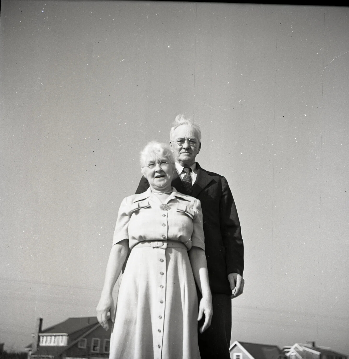 Elderly Couple Standing Portrait, Low-Angle View with Rooftops Below
