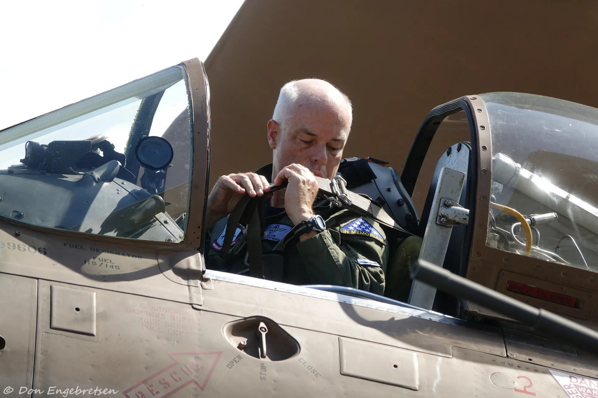 Pilot Fastening Harness in Warbird Cockpit, 'In Memoriam' Patch Visible