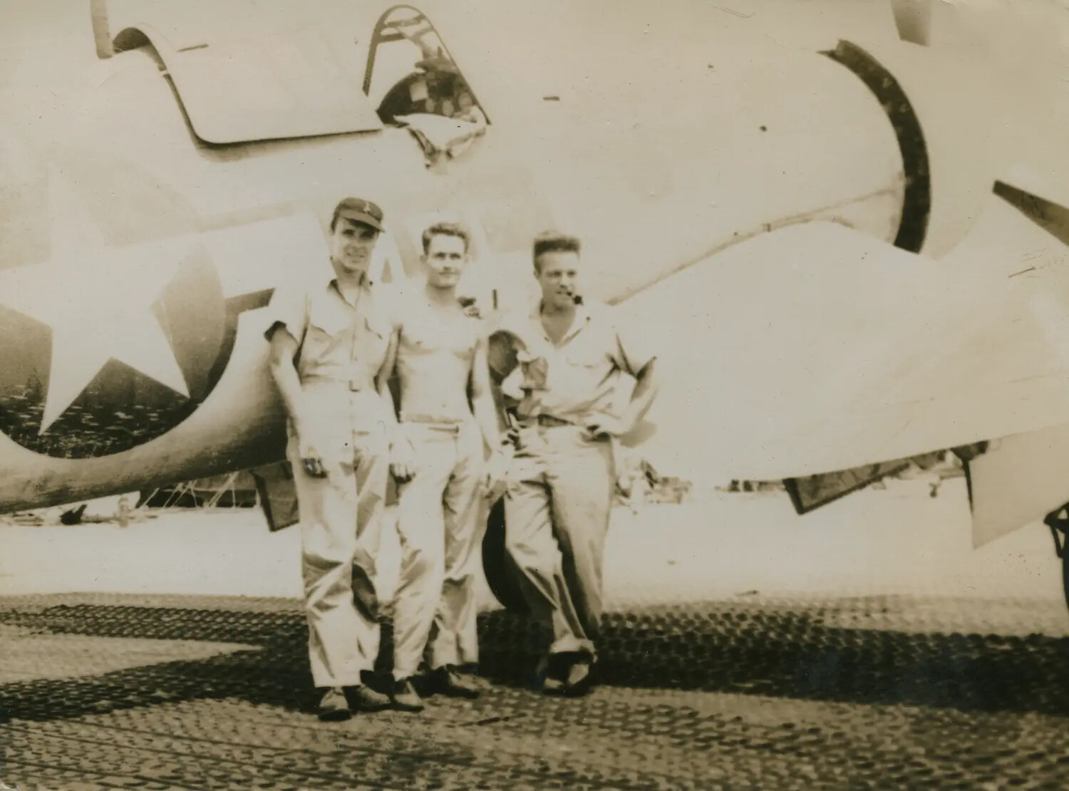 Three Servicemen Posing Beneath Aircraft Nose on Marston Mat Airstrip, Pacific Theater, WWII