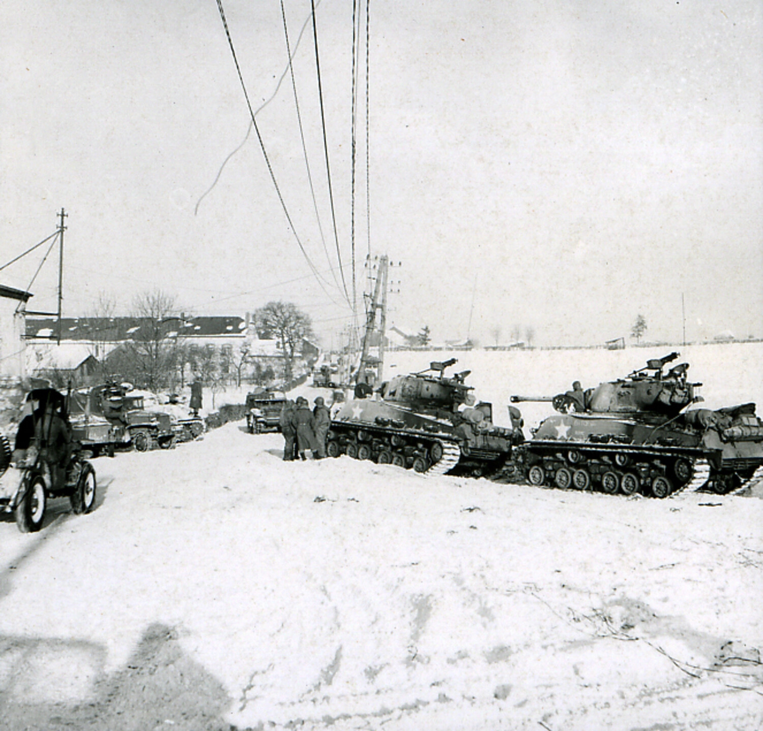 American M4 Sherman Tanks Halted on Snow-Covered Village Road, Winter 1944-1945