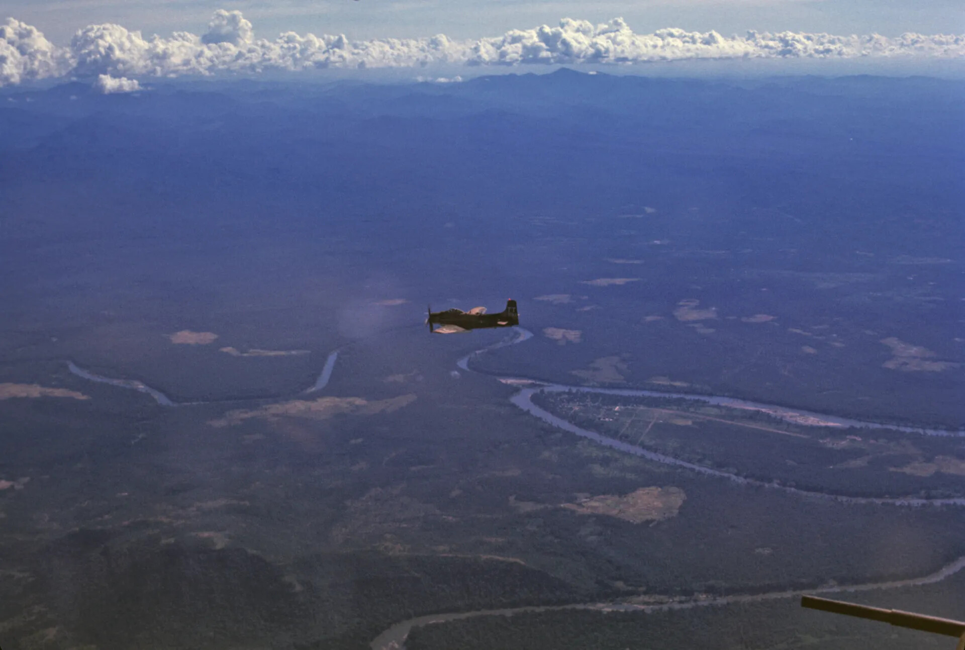 Douglas A-1 Skyraider in Low-Level Flight Over River Valley, Southeast Asia, circa 1970
