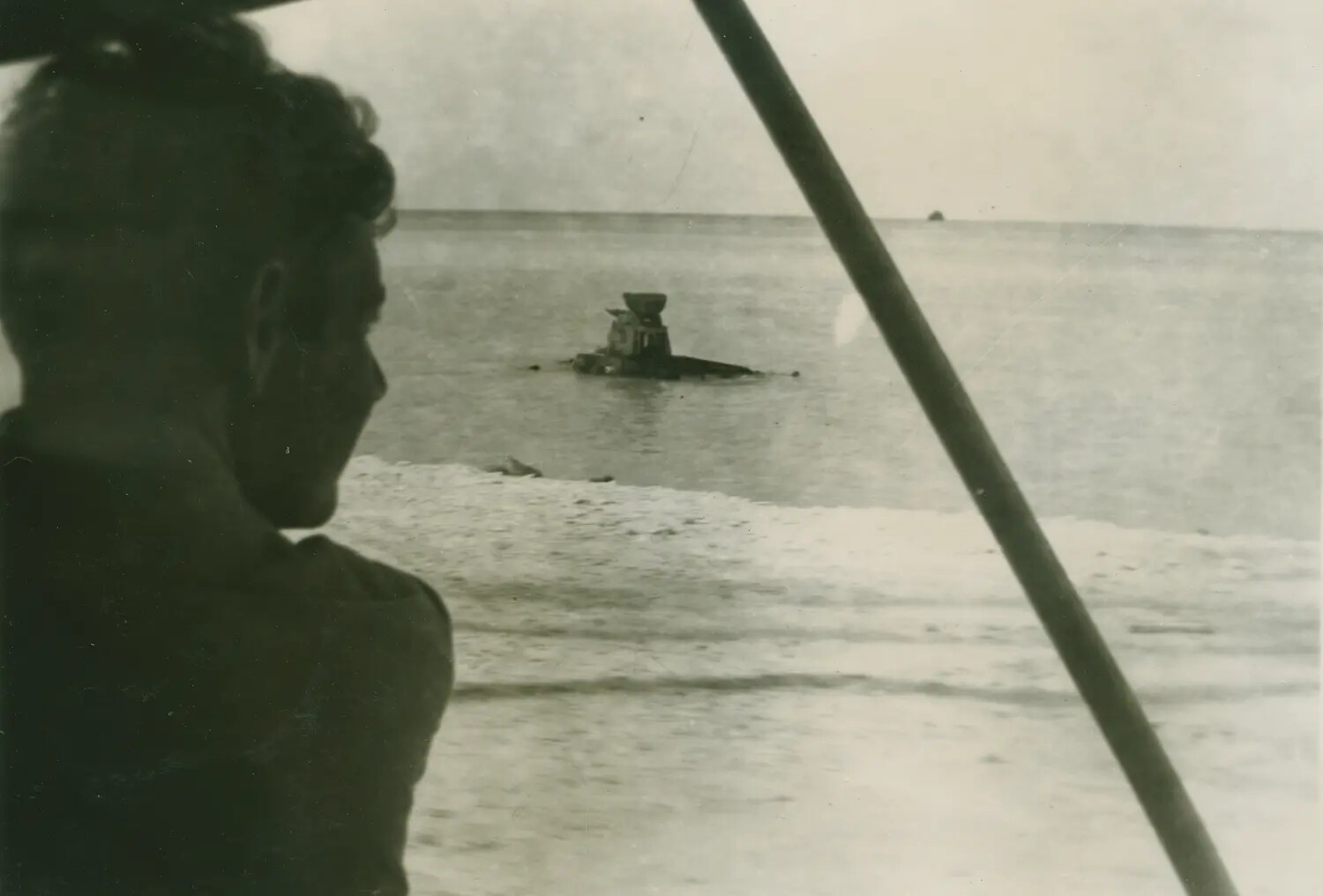 Serviceman Viewing Partially Submerged Wreck in Pacific Lagoon, Edward P. McAleer Collection, WWII