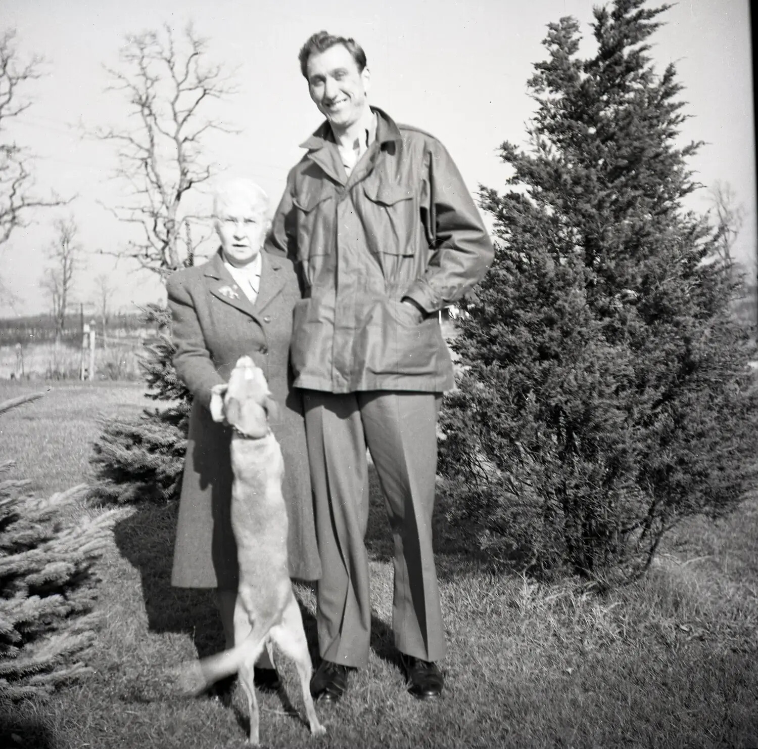 Family Snapshot of a Woman and Man with a Dog in a Garden