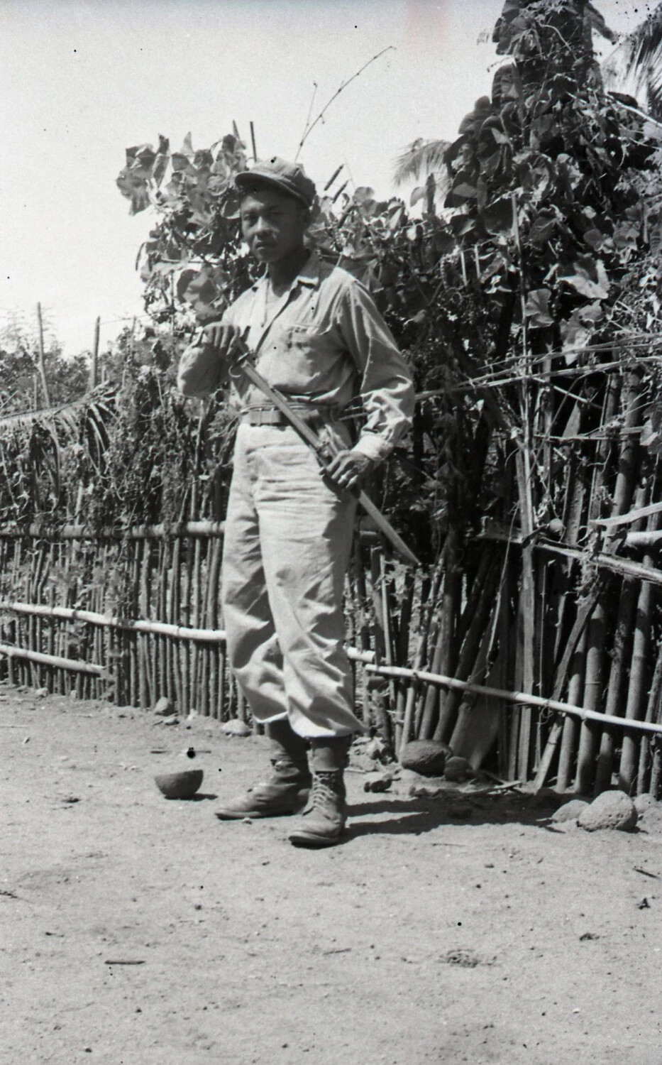 Man with Sword or Bolo Beside Bamboo Fence, Luzon, Philippines, World War II Era