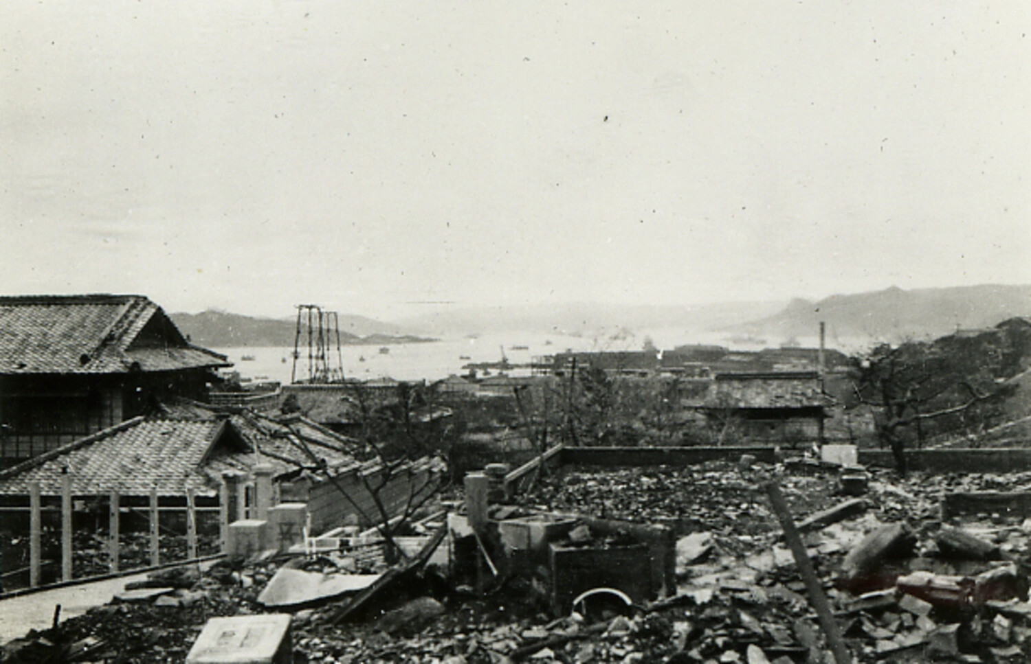View of Bomb-Damaged Japanese Port City with Surviving Traditional Houses in Foreground, Postwar Japan