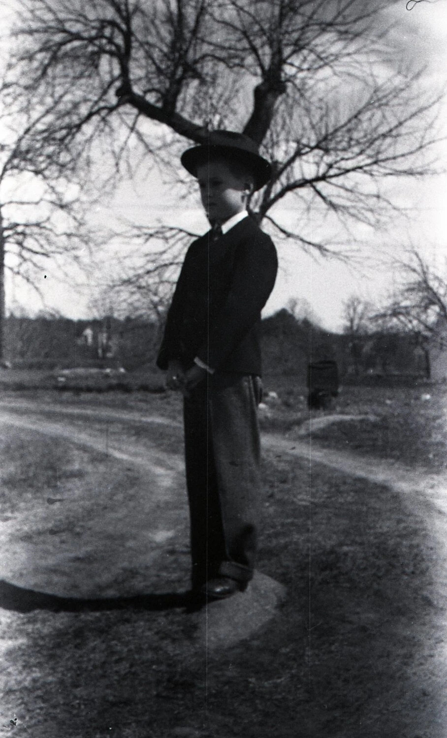 Young Boy in Suit and Hat on a Country Road