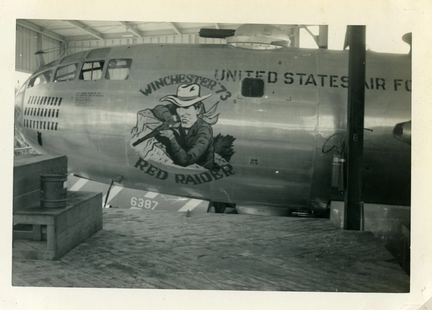 Nose Art 'Winchester "73" Red Raider' on USAF B-29/B-50 Superfortress-Type Bomber Under Hangar Shelter