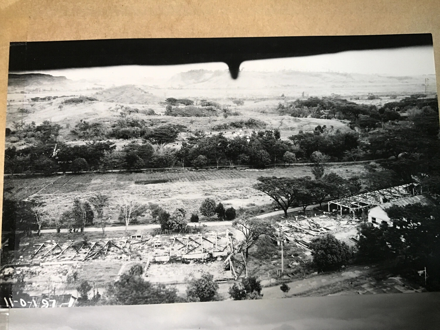 Aerial View of Damaged Storage Structures and Surrounding Airfield Terrain