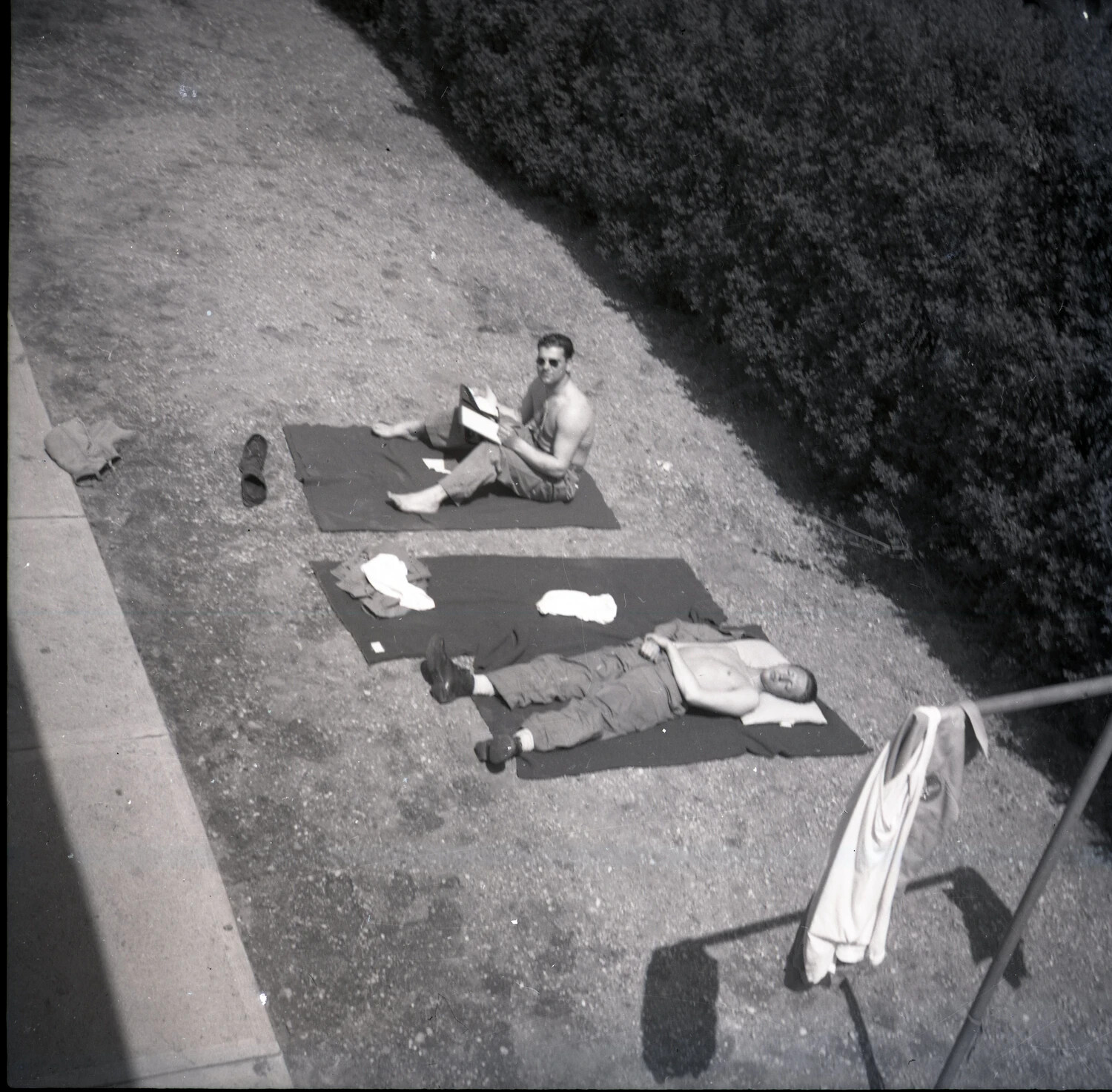Two Off-Duty Servicemen Sunbathing on Blankets, Viewed from Above