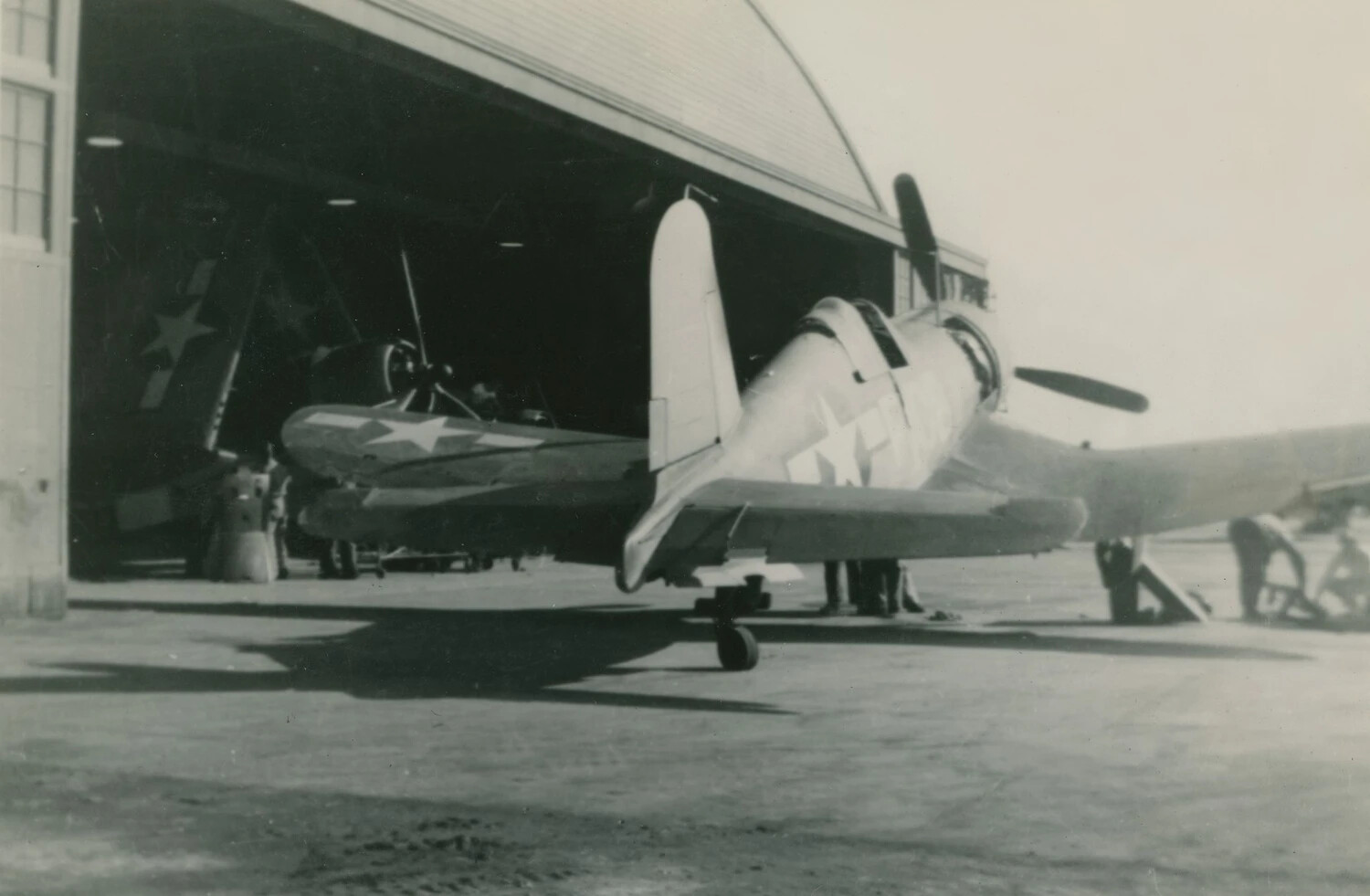 U.S. Navy Carrier Fighter (Grumman F6F Hellcat) with Wing Folded, Outside Hangar - McAleer Photo Album