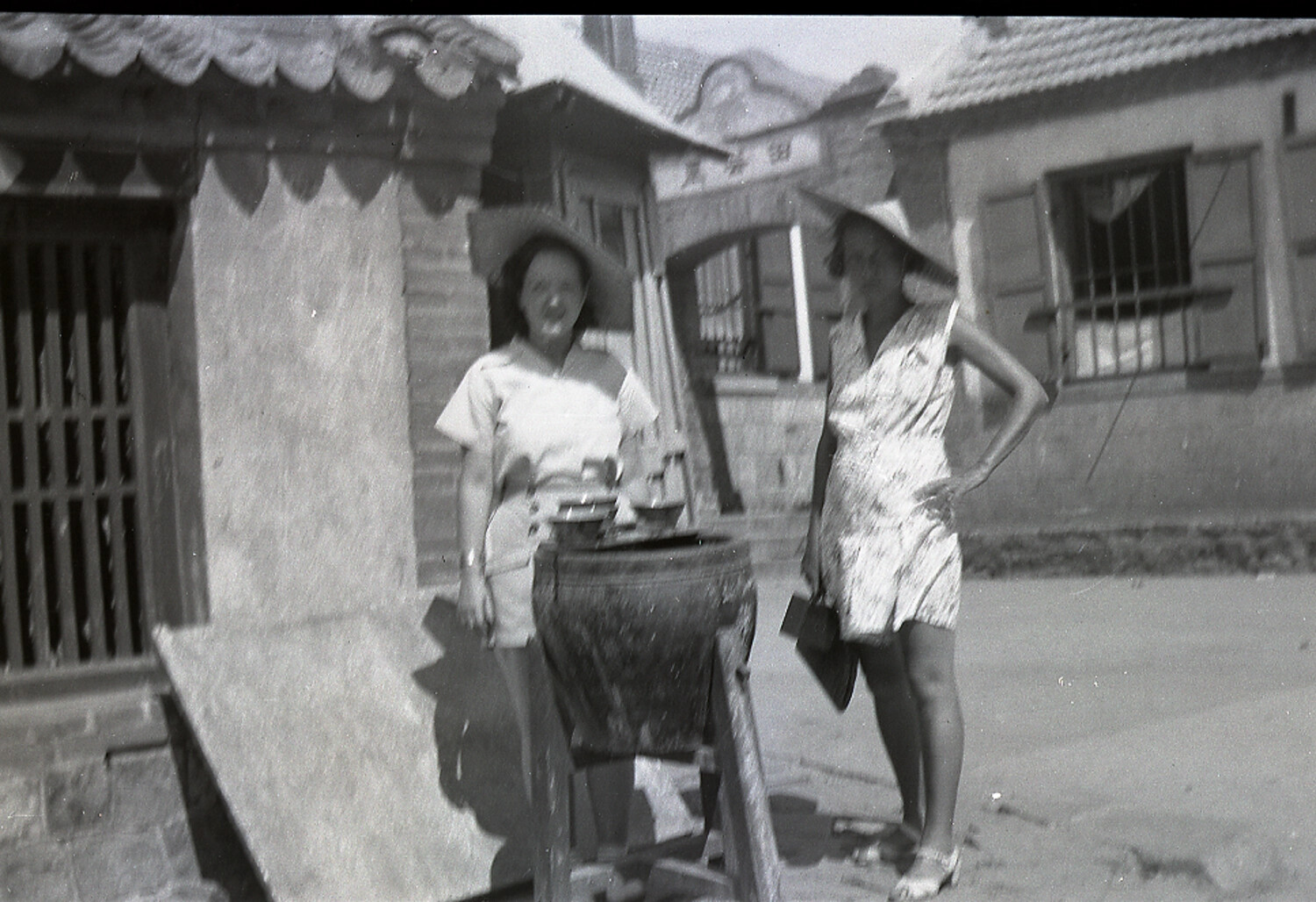 Two Western Women Beside a Charcoal Stove, Chinese Village Street