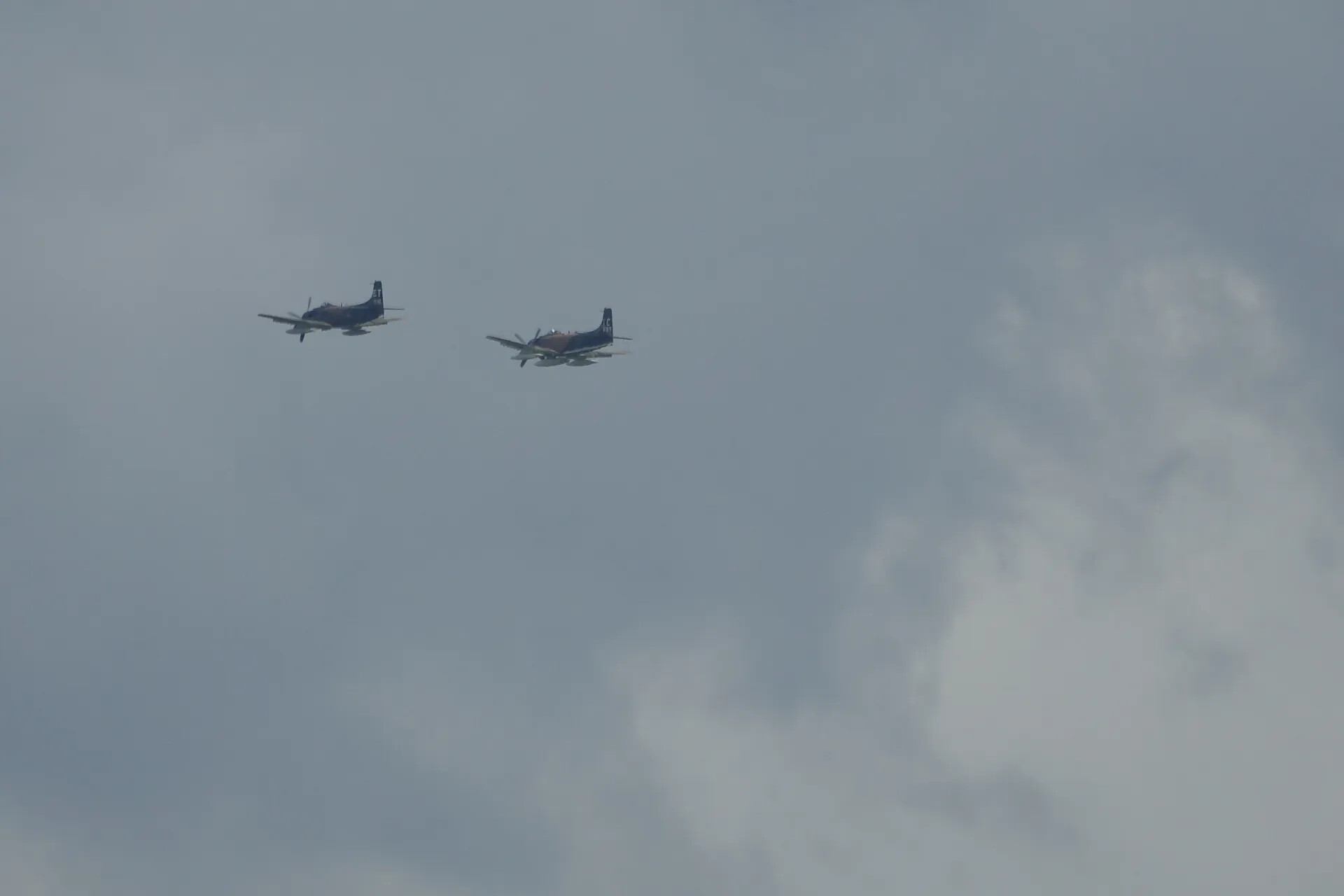 Two A-1 Skyraiders in Formation Flight Over Overcast Sky, Tail Codes ET and TC 965