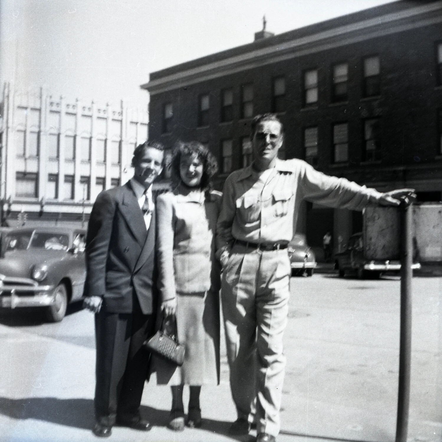 Serviceman in Khaki Uniform Posing with Two Civilians on a Downtown City Street