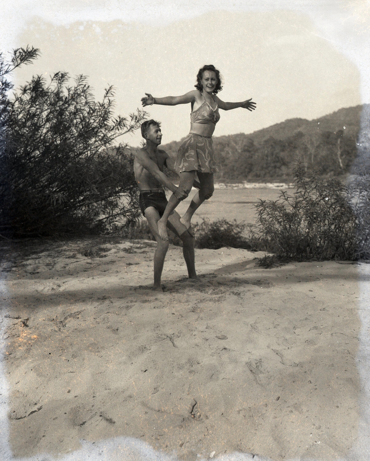 Candid Beach Snapshot, Man and Woman in Acrobatic Pose (WWII-era Personal Photograph, Burma-China-India Theater Collection)