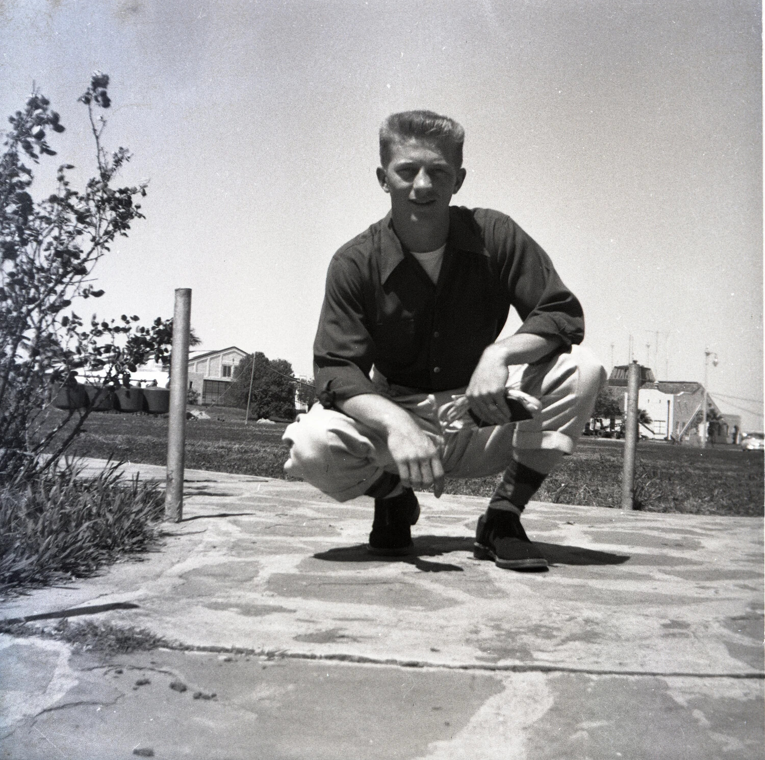 Man Crouching on Walkway, Outdoor Portrait with Distant Townscape, 1950s