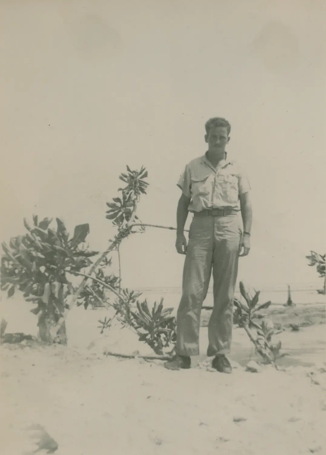 Serviceman in Khaki Uniform on Sandy Coastal Terrain, Pacific Theater, WWII Era