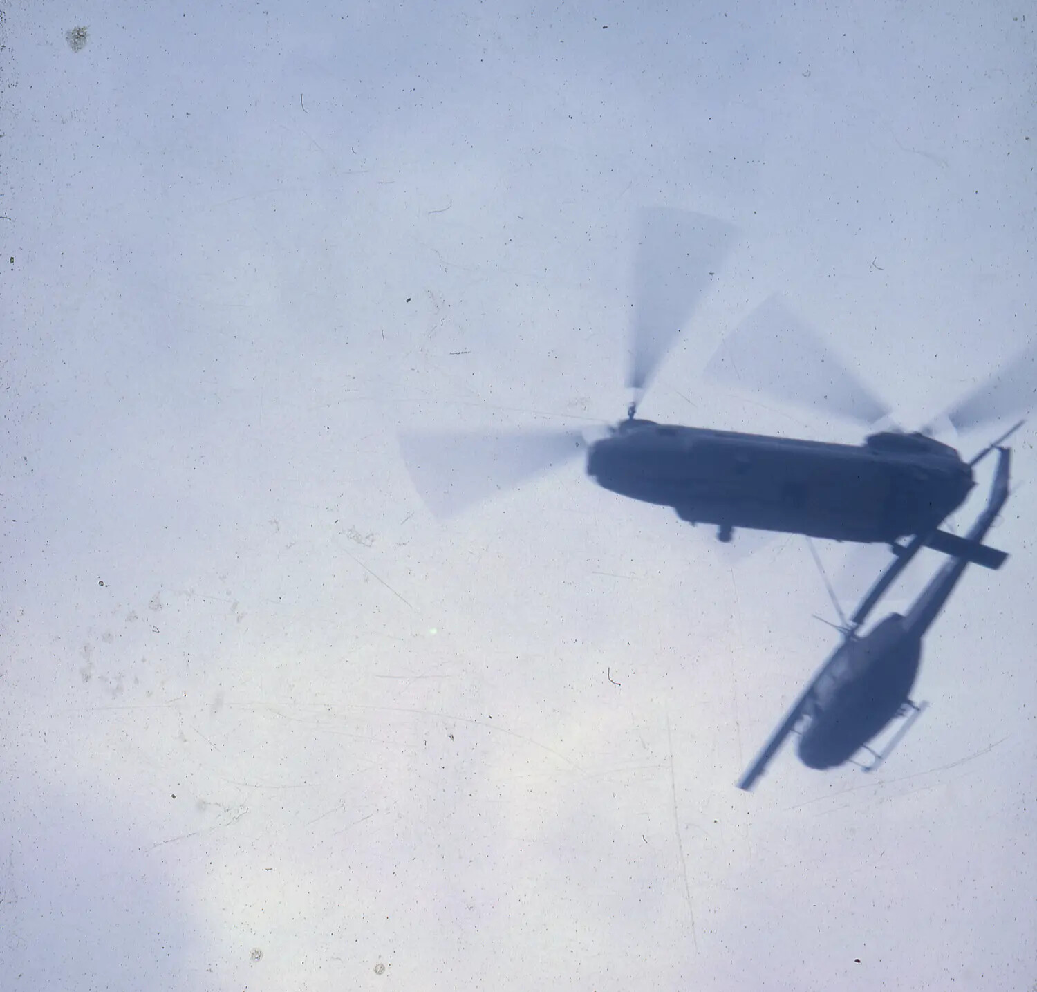 CH-47 Chinook and UH-1 Huey Helicopters in Flight, Silhouette View, Vietnam War