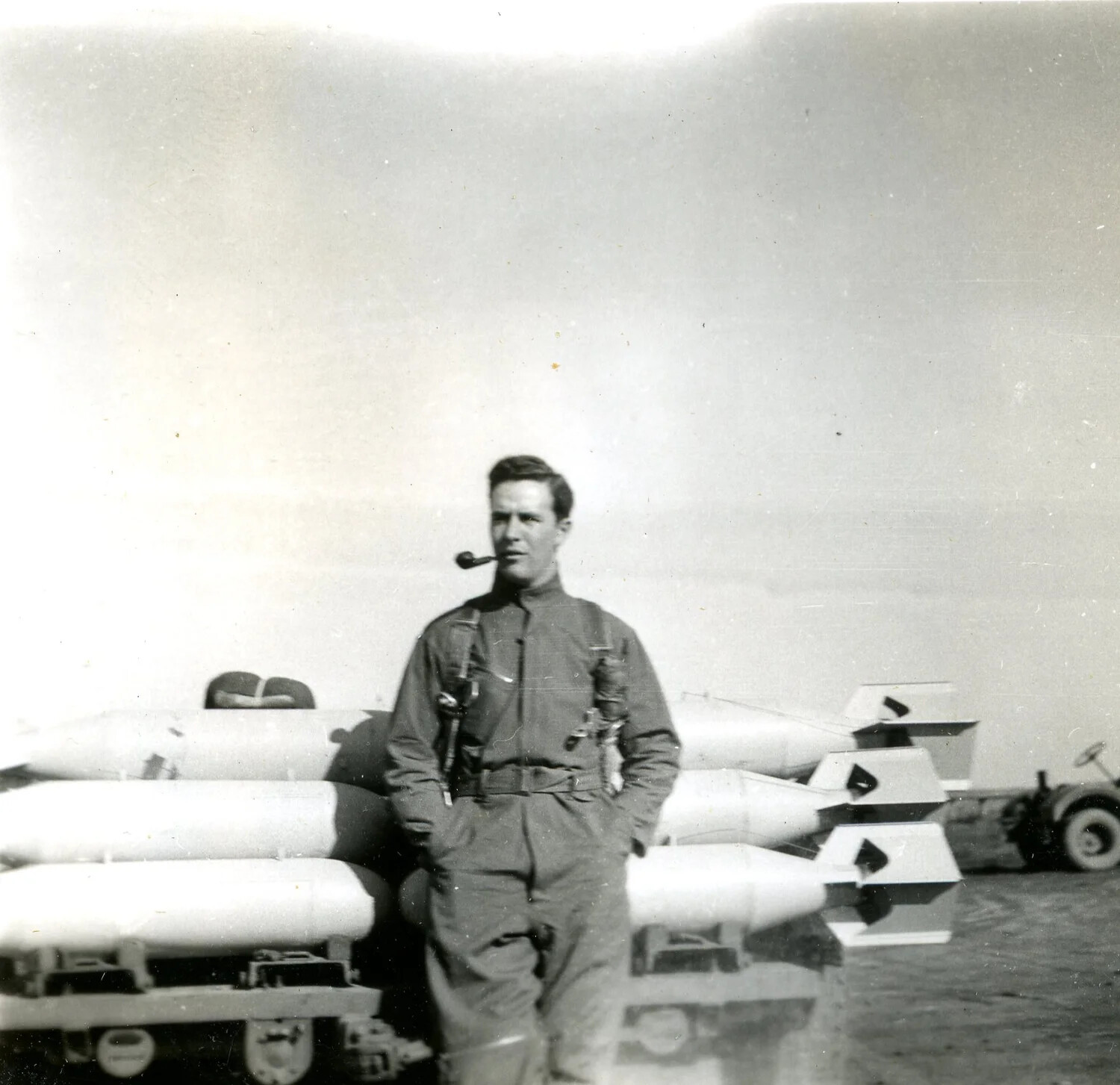 Airman with Pipe Posing Before Stacked Aerial Bombs, Ie Shima, 345th Bomber Group, WWII