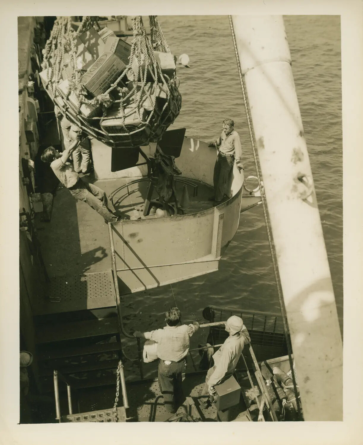 Underway Replenishment Operation Aboard USS Petrof Bay (CVE-80), Cargo Net Lowered into Gun Tub