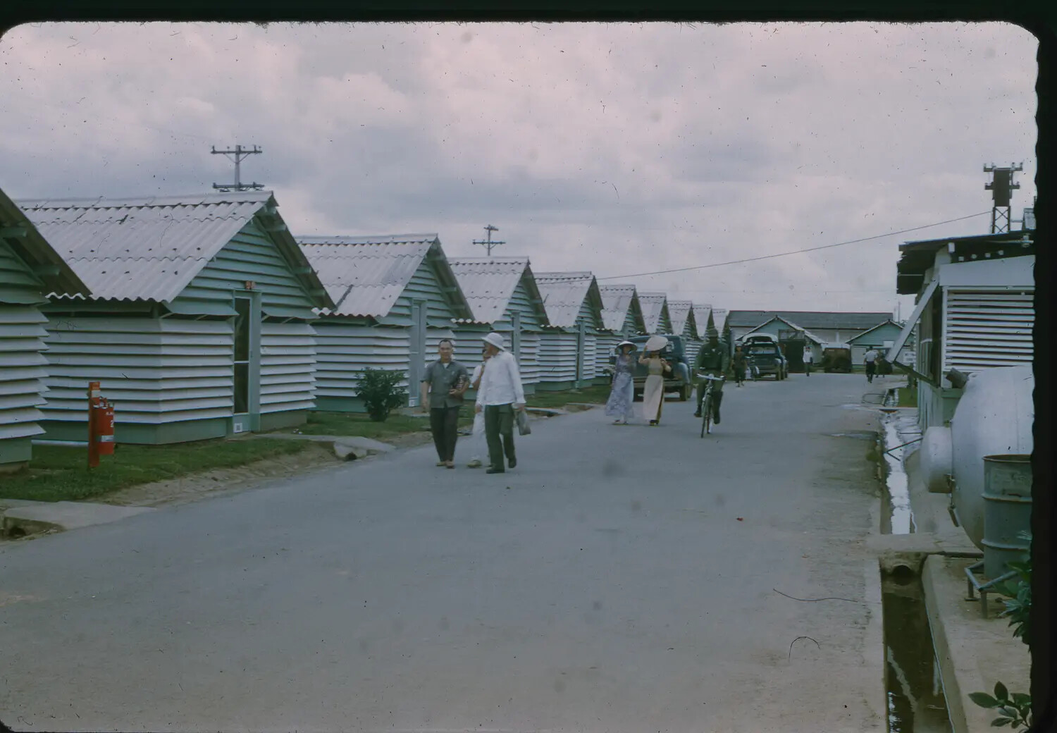 Housing Row and Vietnamese Civilians Near U.S. Air Base, Vietnam, 1965