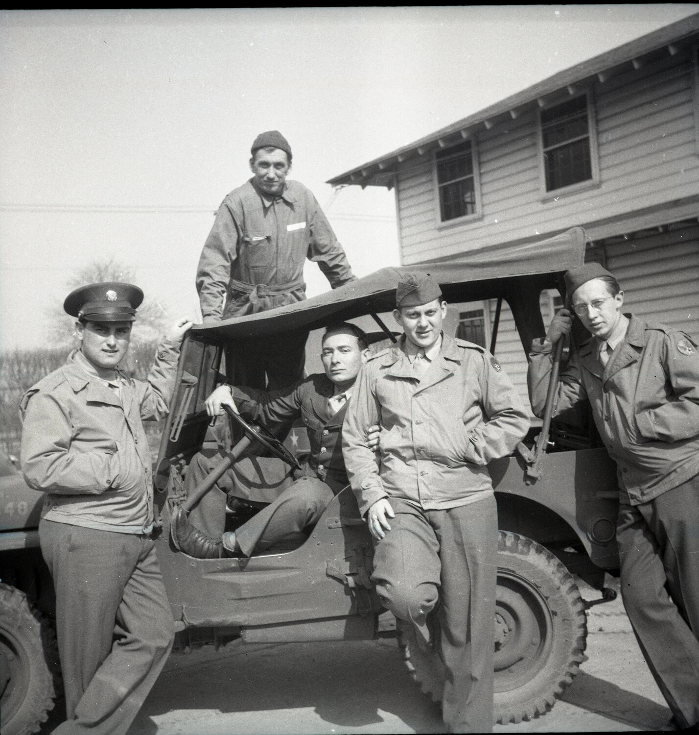 Group Portrait of Five Servicemen with Military Jeep at Barracks