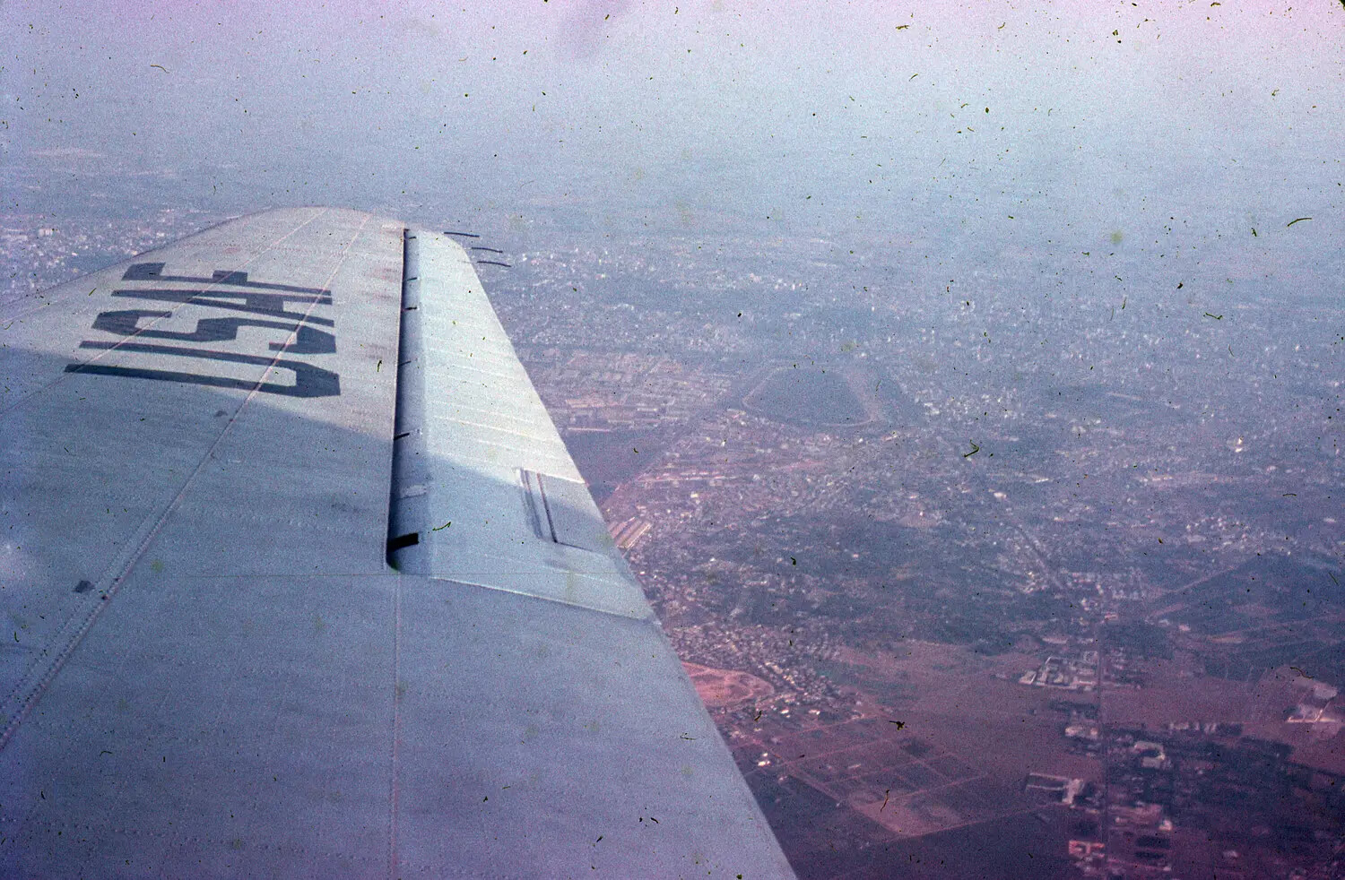 View of Aircraft Wing and USAF Marking Over a Vietnamese Town, 1965