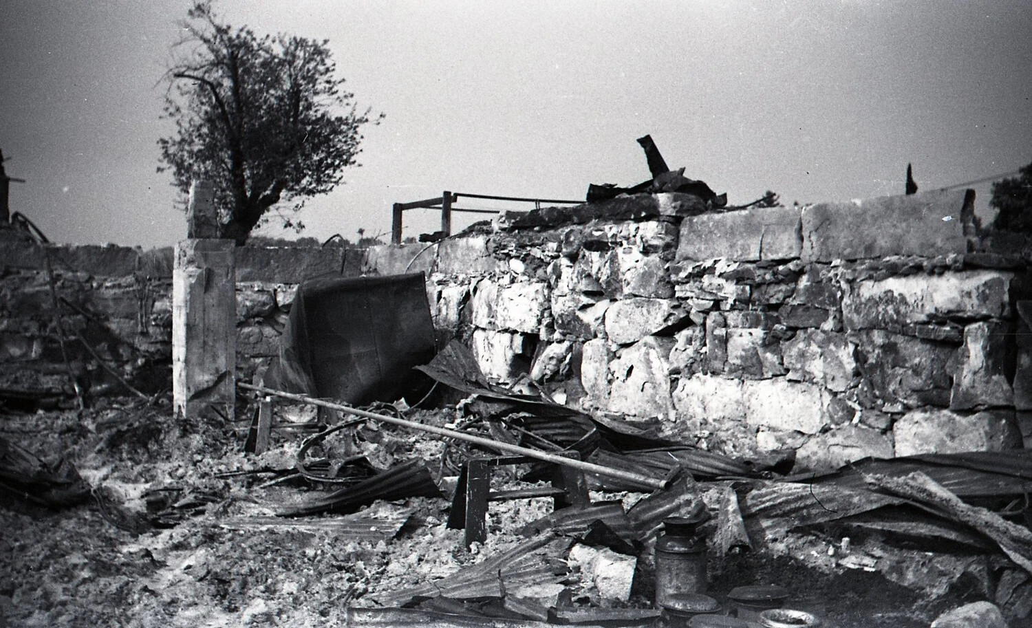 Overturned Trough and Scattered Roofing Debris at Burned Dairy Farm