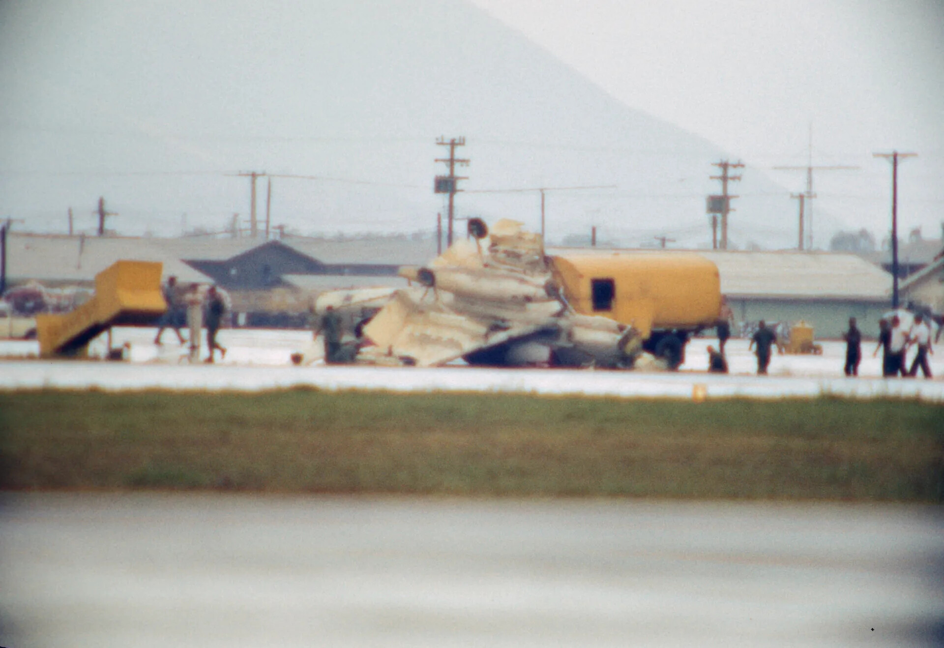 Aircraft Wreckage Debris Pile with Ground Personnel at Airbase Crash Site