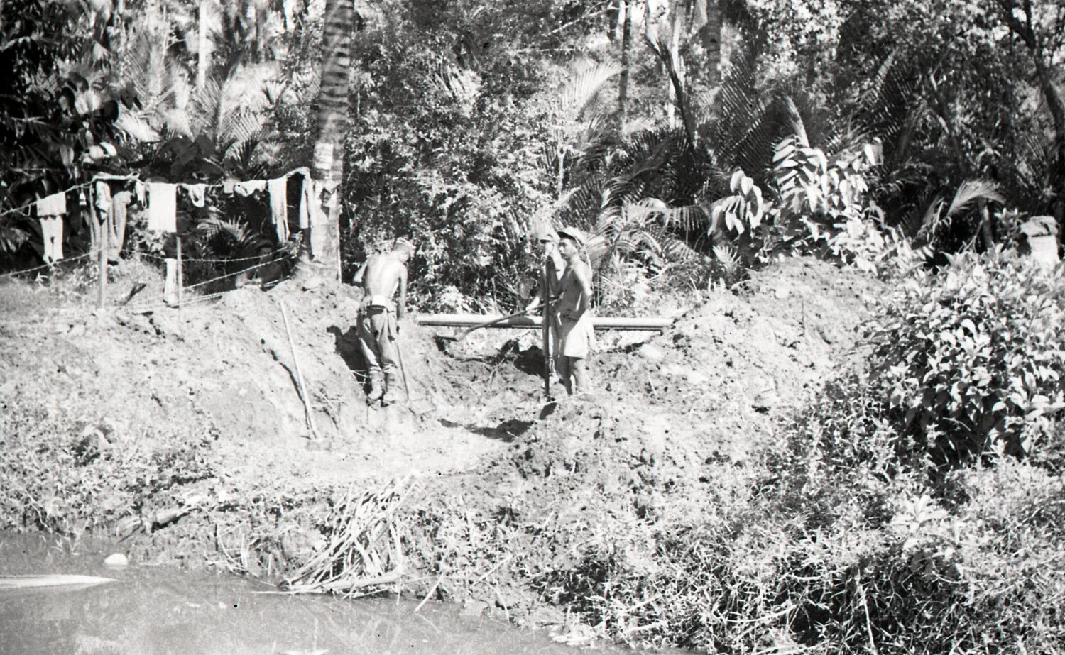U.S. Servicemen Digging and Laying Pipe Along a Jungle Waterway, Luzon, Philippines, World War II