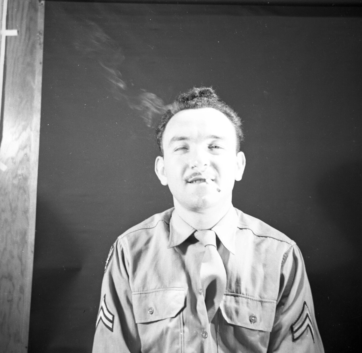 Candid Portrait of U.S. Army Corporal with Cigarette, Playful Expression