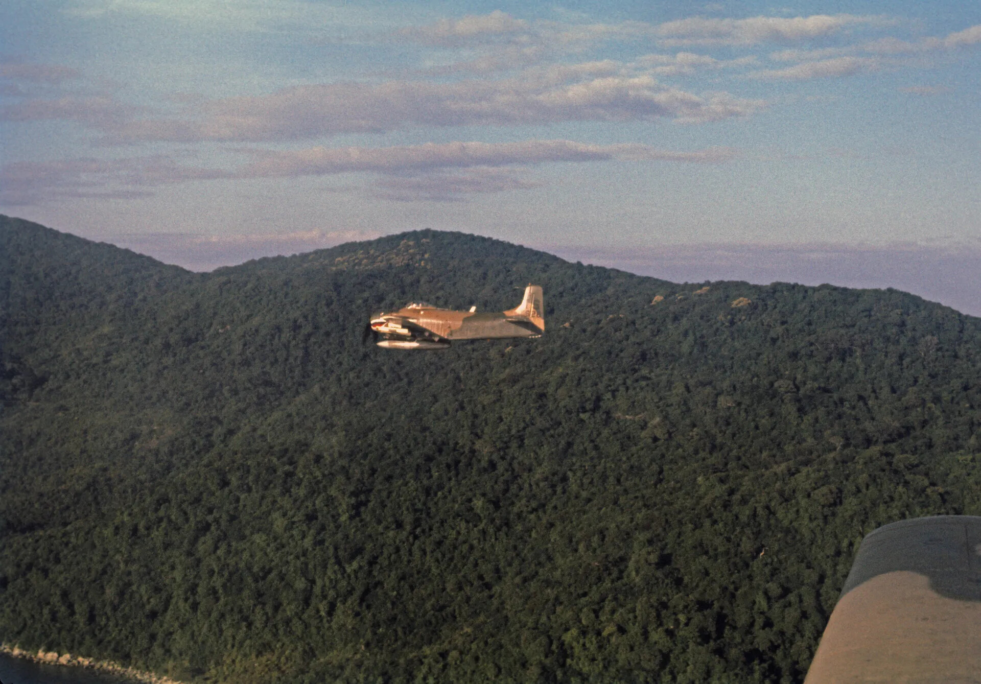 A-1 Skyraider in Flight Over Coastal Mountain Terrain, Vietnam War Era
