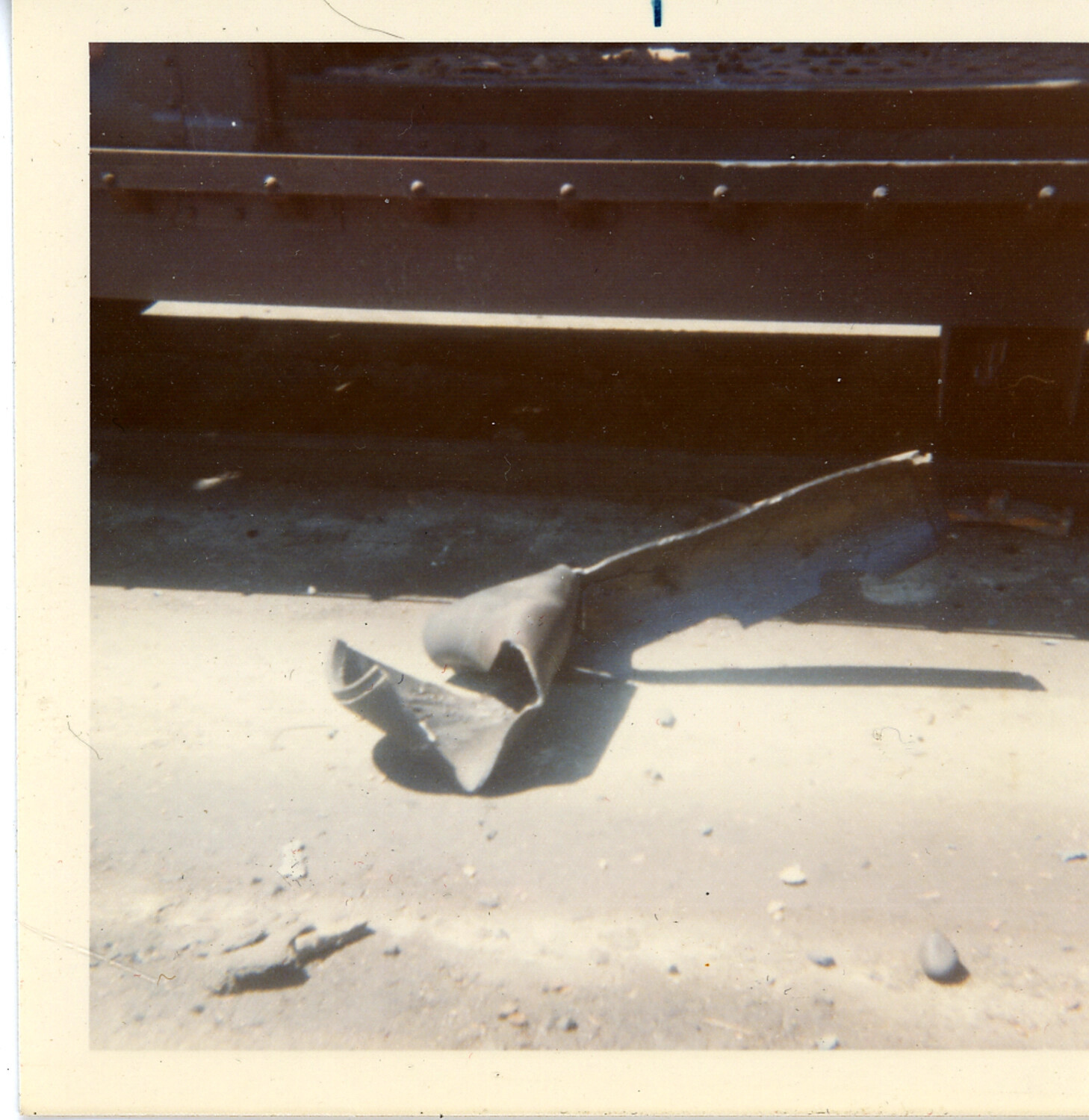 Bomb Fin Assembly Debris Beneath Rail Car Trucks, Roseville Yard, California, 1973