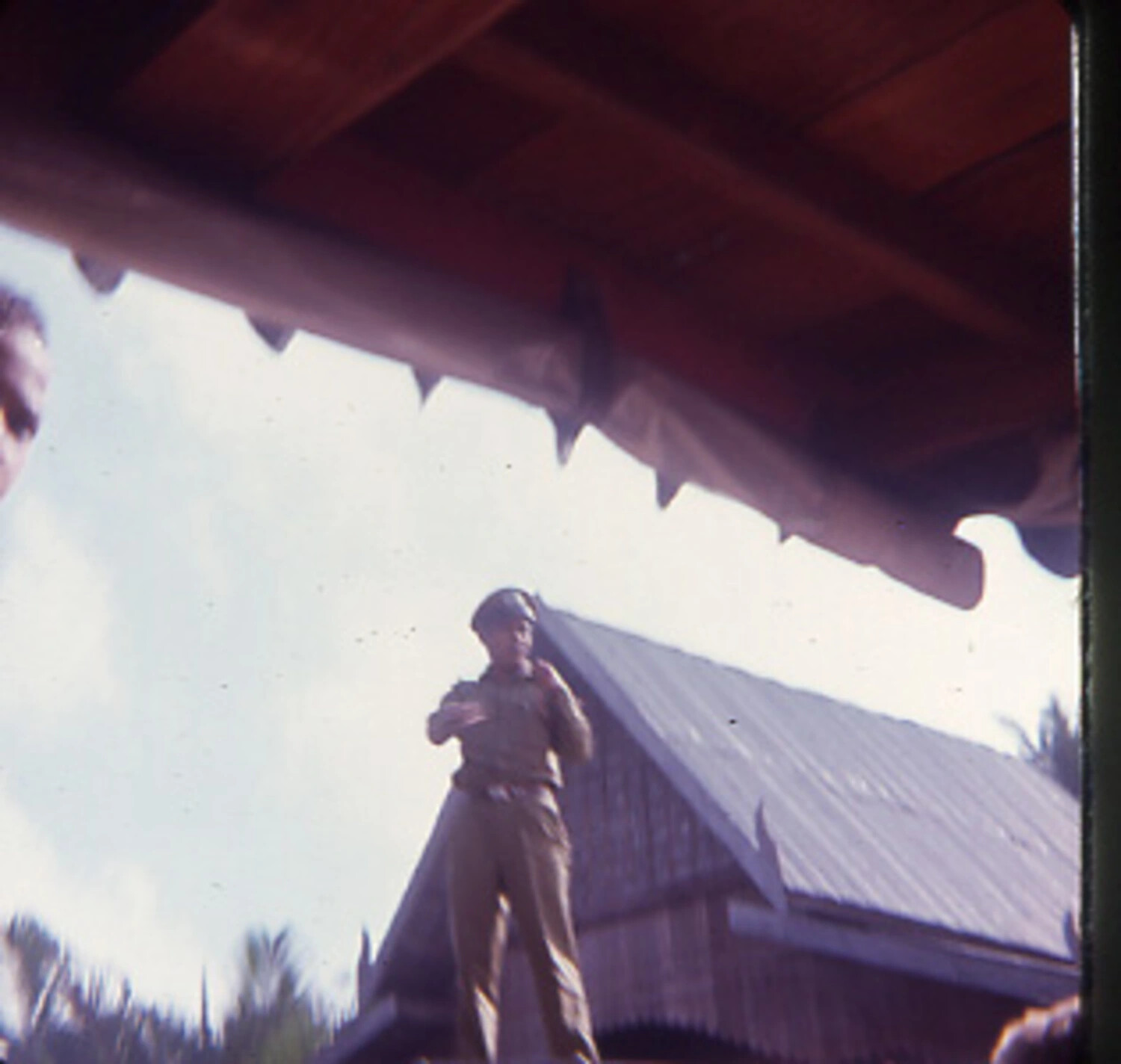 Serviceman Beneath Traditional Gabled Roofline, Southeast Asia, Vietnam War Era