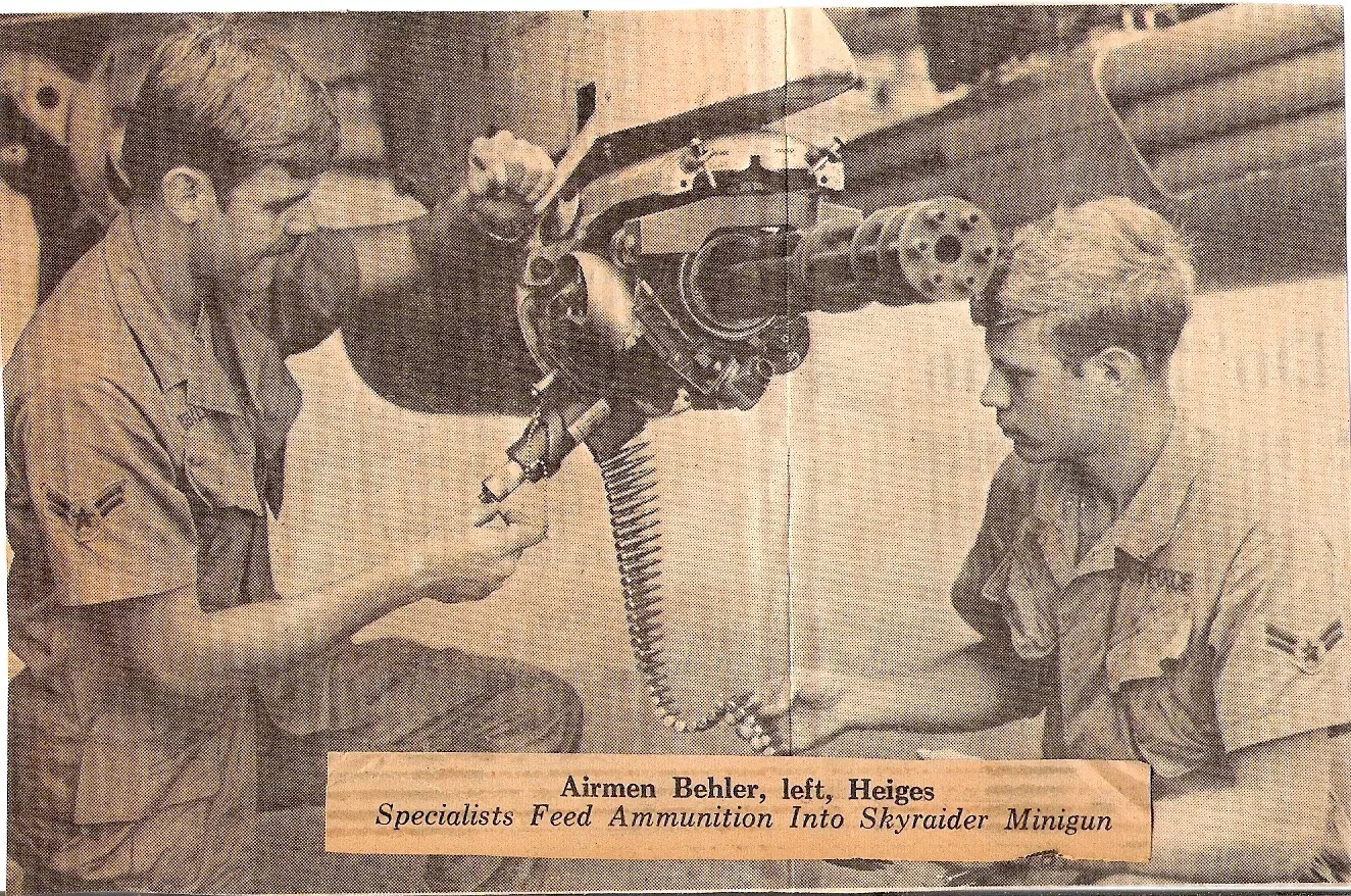 Newspaper Clipping: Airmen Behler and Heiges Load Ammunition Into A-1 Skyraider Minigun