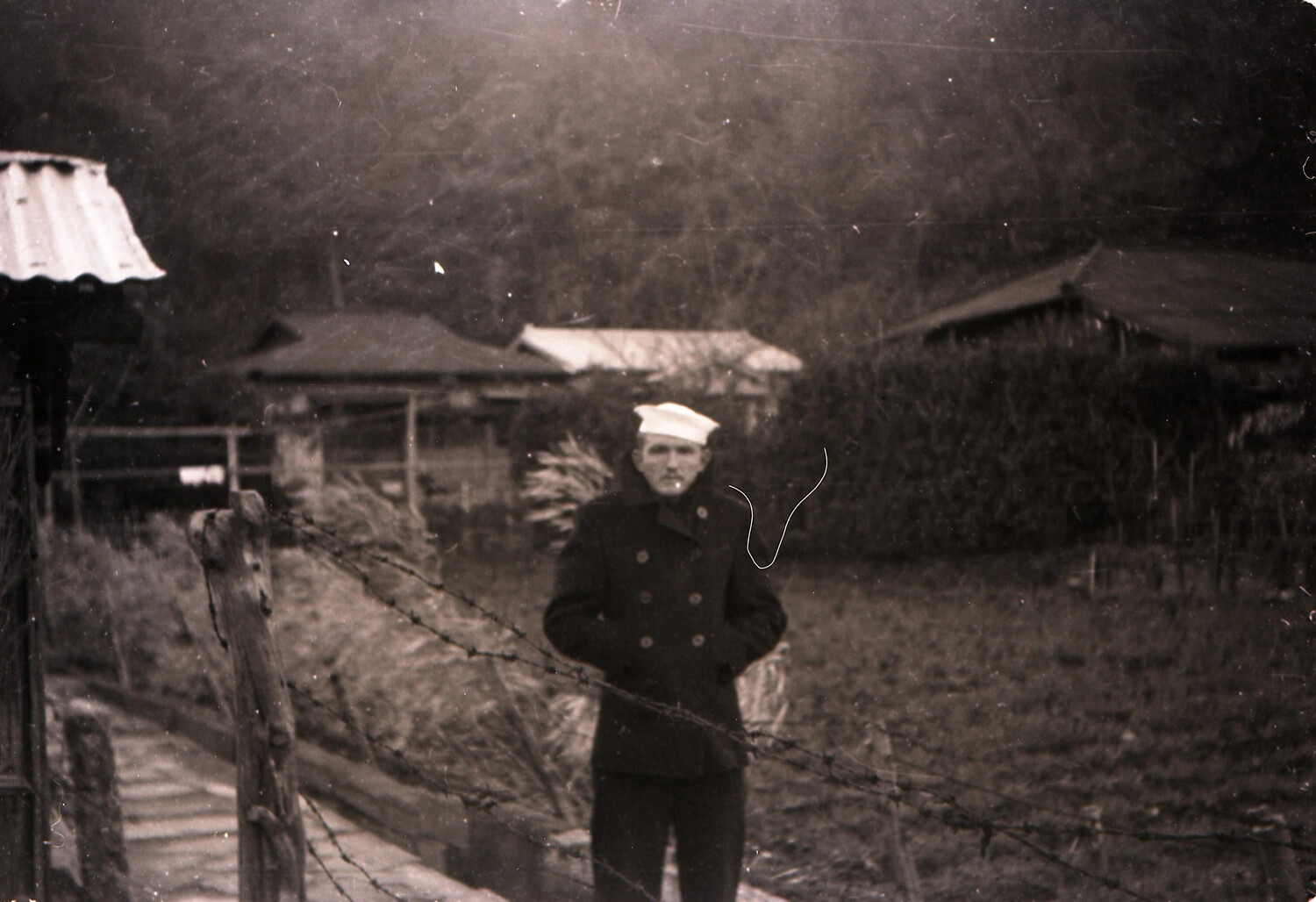 U.S. Navy Sailor at a Rural Fence Line, likely Japan, early-to-mid 1950s