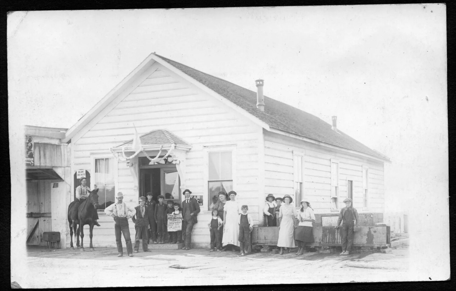 Community Group Portrait Outside General Store with Bunting, c. early 1910s