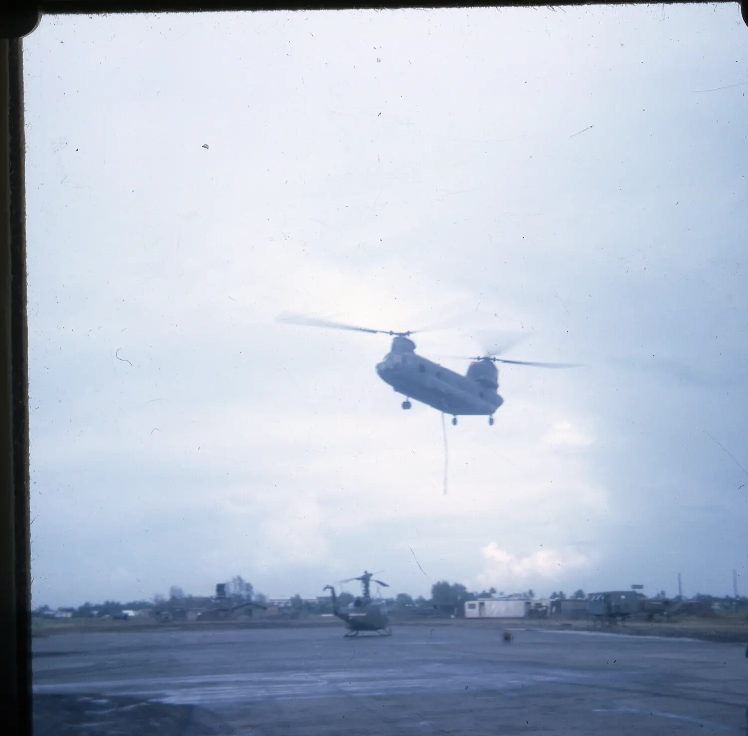 CH-47 Chinook Helicopter in Flight Over Airfield with UH-1 Huey on Ground, Vietnam War Slide Collection