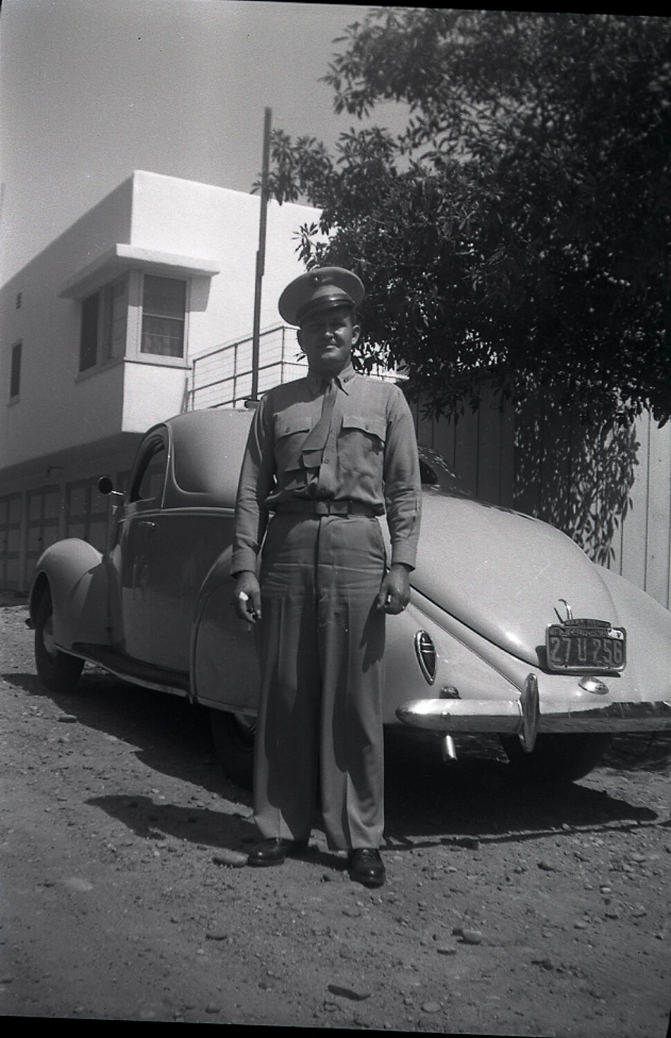 Uniformed Serviceman Beside a Streamlined Coupe, Late 1930s