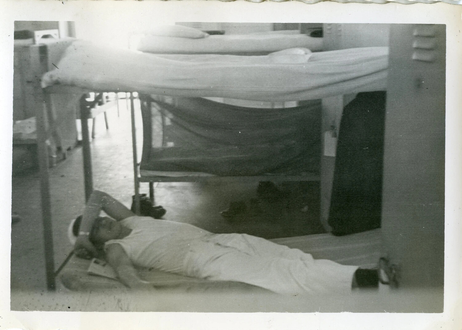 Serviceman Resting Beneath Bunk in Barracks with Mosquito Netting, NAS Agana, Guam