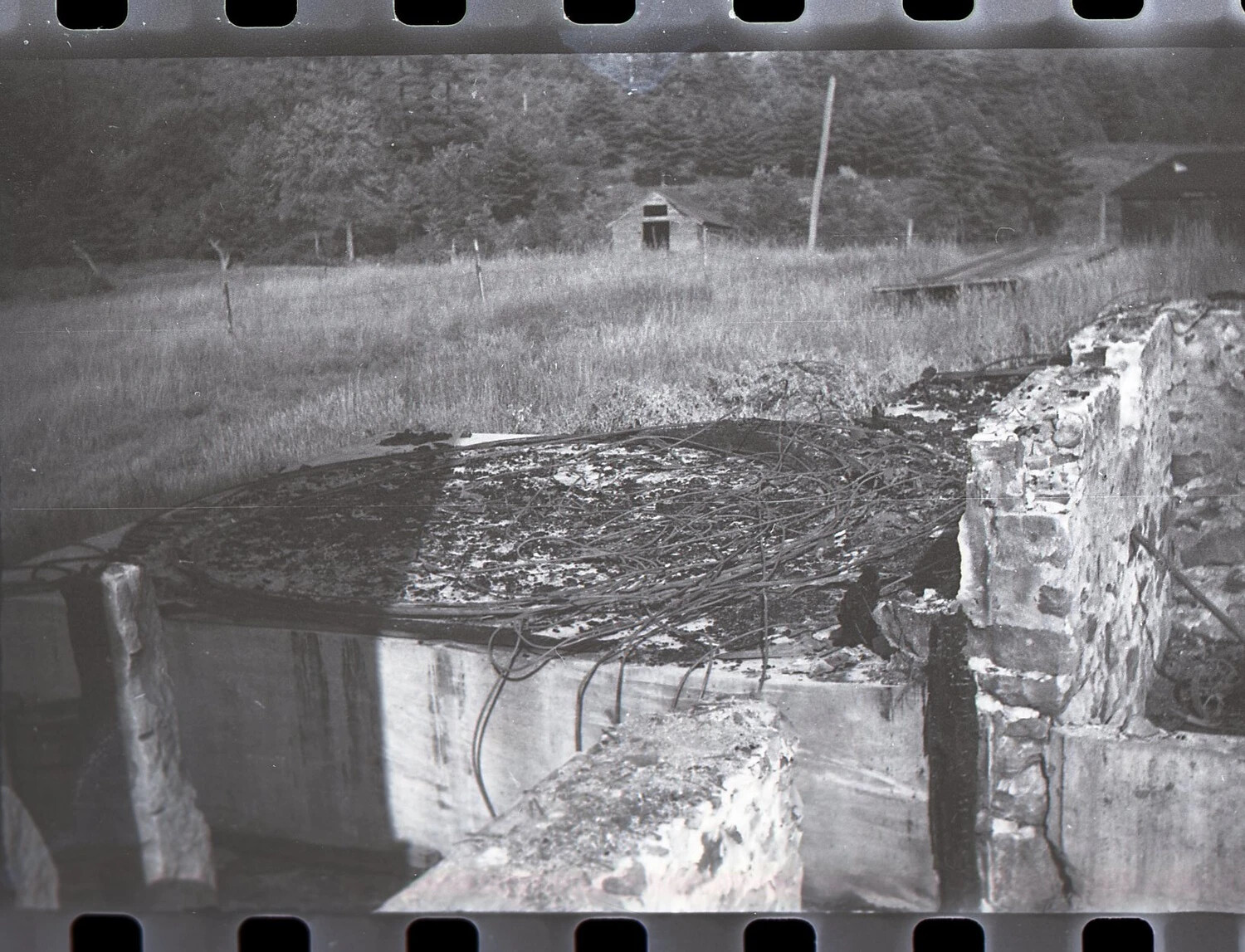 Full-Frame Negative: Close View of Fire-Damaged Concrete Tank with Warped Wiring, Dairy Farm, c. 1940s
