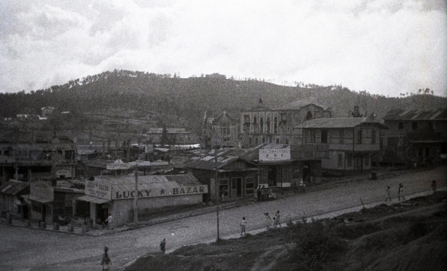 War-Damaged Town Street with 'Lucky Bazar' Shop, Luzon, Philippines, WWII