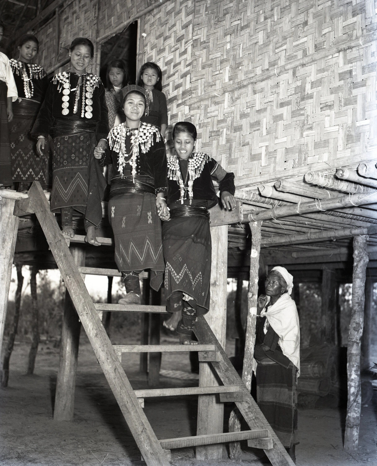Karen Women in Traditional Dress Descending Stilt House Ladder, Burma - WWII China-Burma-India Collection ("Karen Church Service")