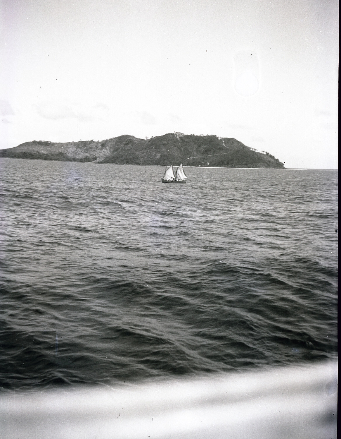 Local Sailing Vessel Off a Coastal Headland, China/Pacific Coast, 1930s (Pre-WWII U.S. Navy Photograph)