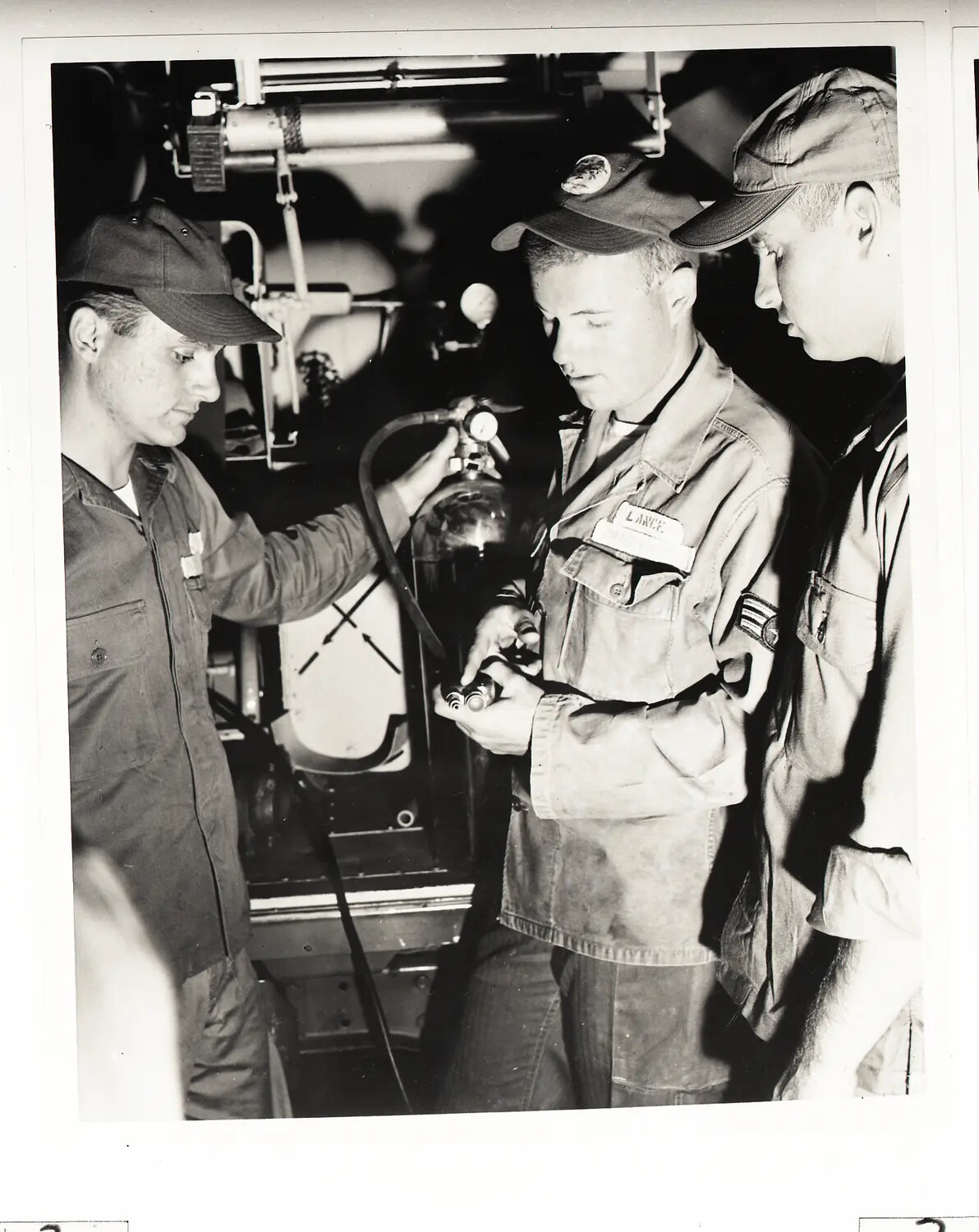 146th Air Transport Wing Airmen Inspecting Fire Extinguisher/Oxygen Cylinder Fitting, September 1960