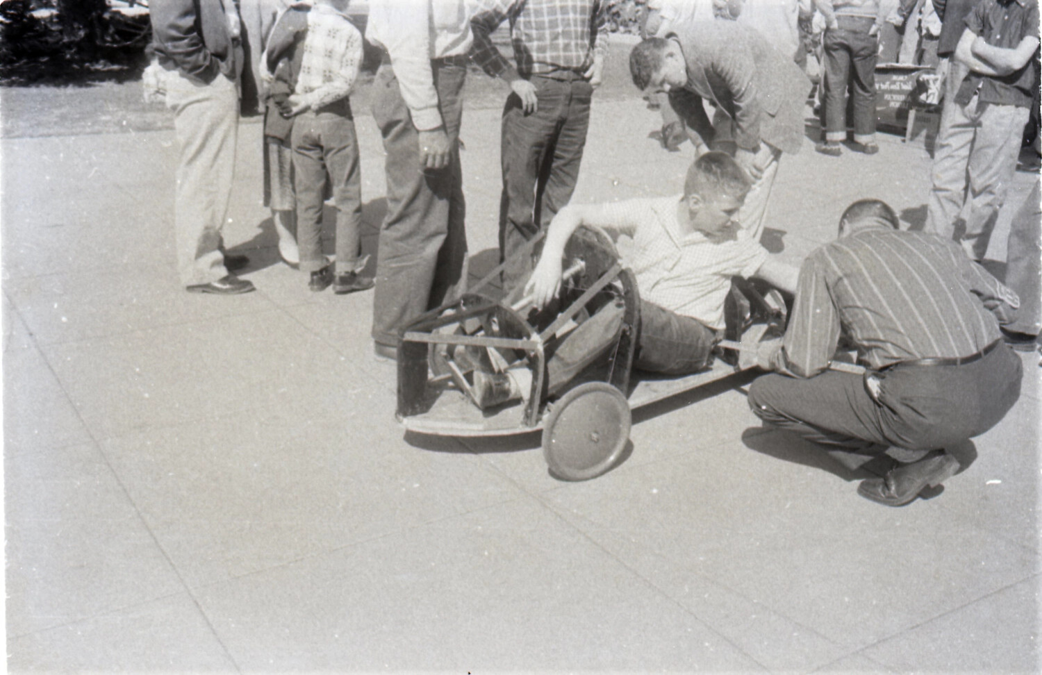 Boy in Homemade Soap Box Derby Racer Surrounded by Spectators