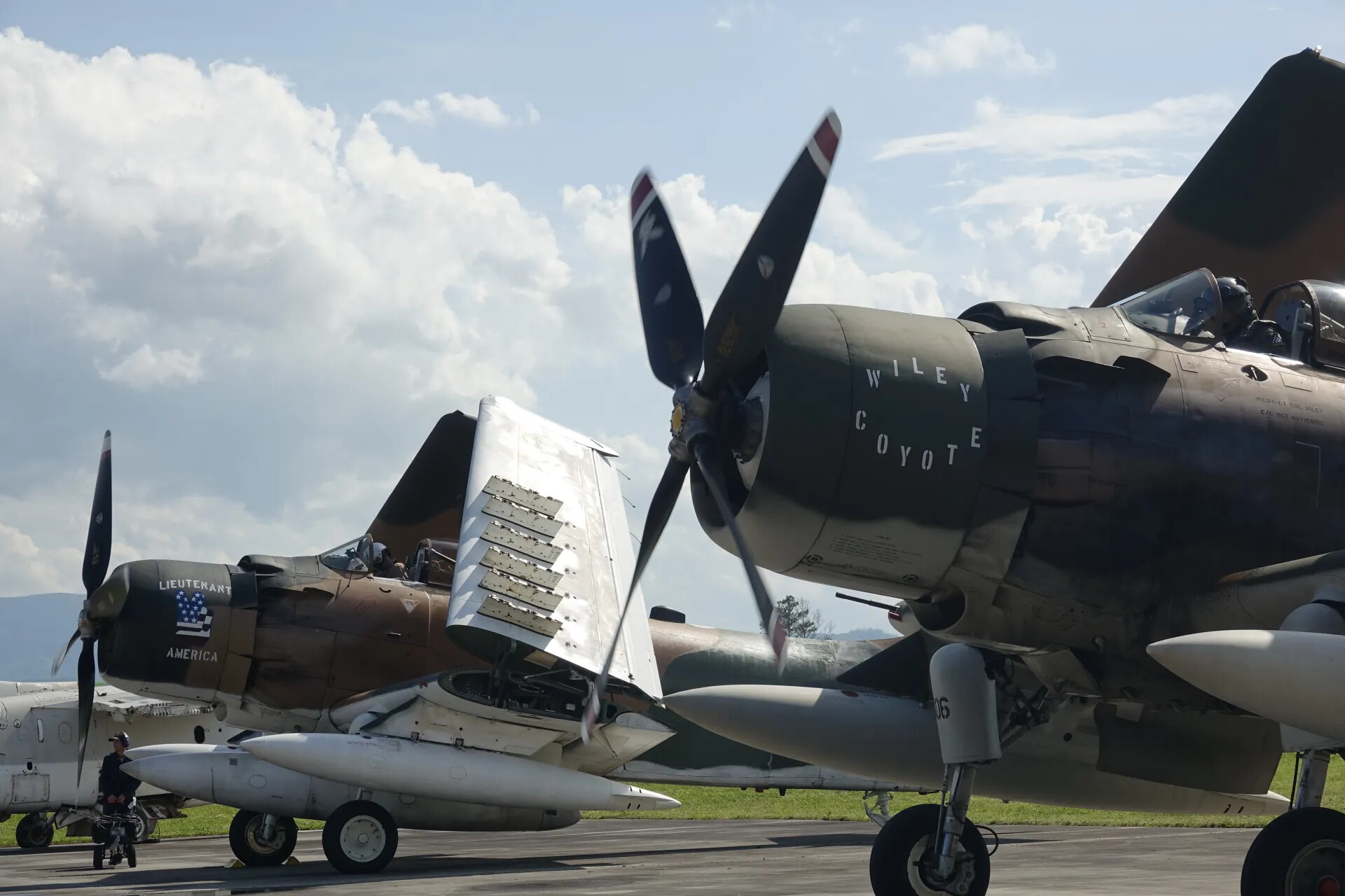 A-1 Skyraiders 'Lieutenant America' and 'Wiley Coyote' Parked Together, Propellers Crossed in Frame
