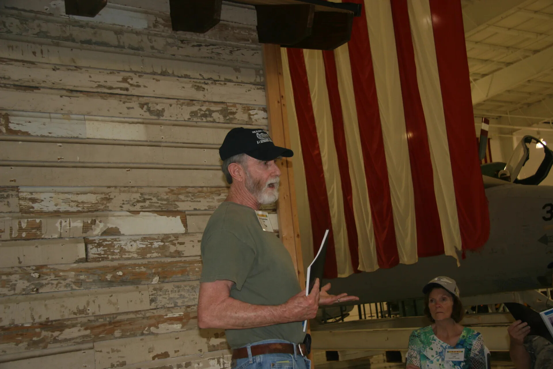 Speaker Addressing Attendees at Veterans Reunion Event, A-1 Skyraider Association Cap
