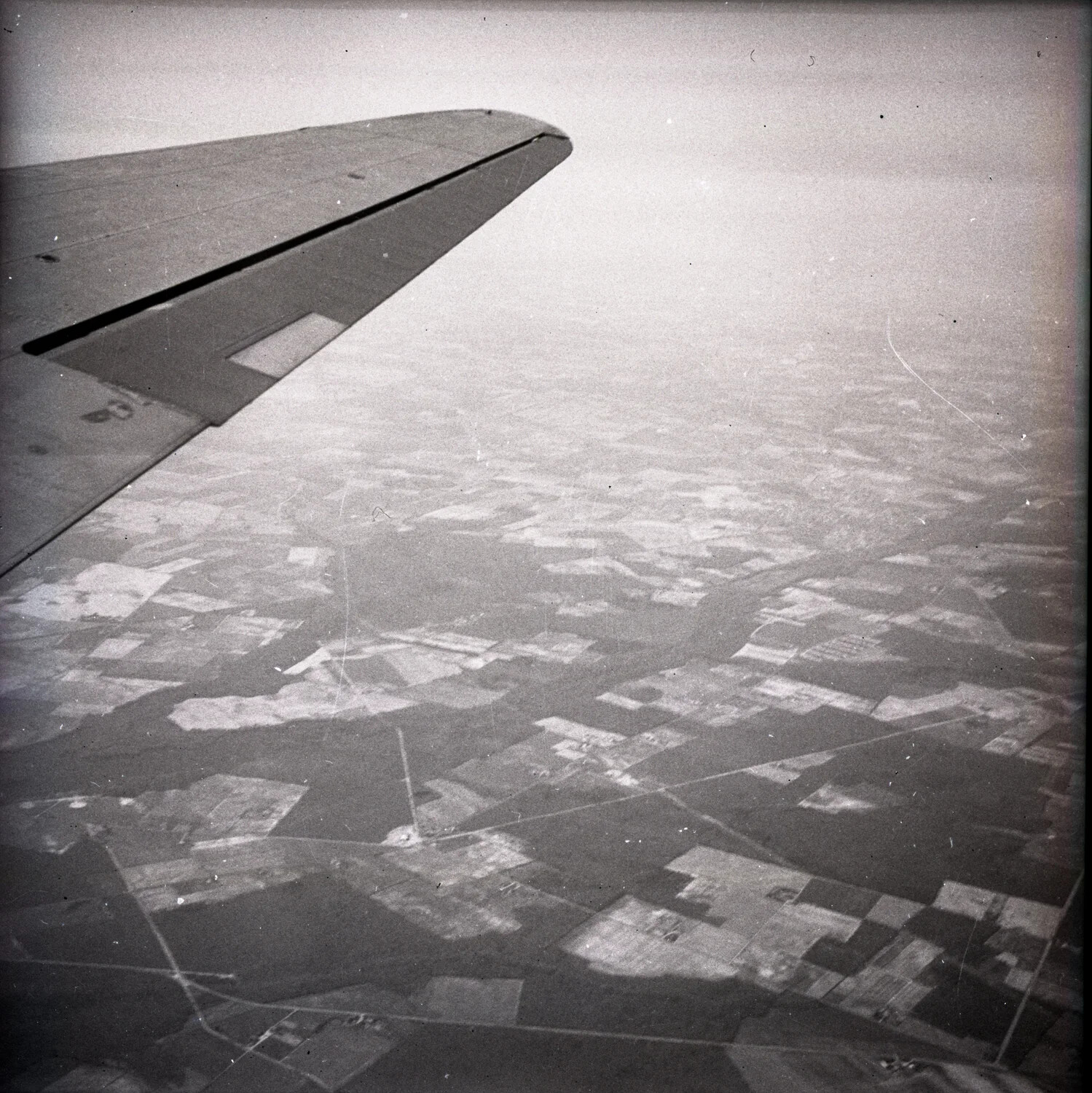 Aerial View from Aircraft Wing Over Farmland, WWII Era