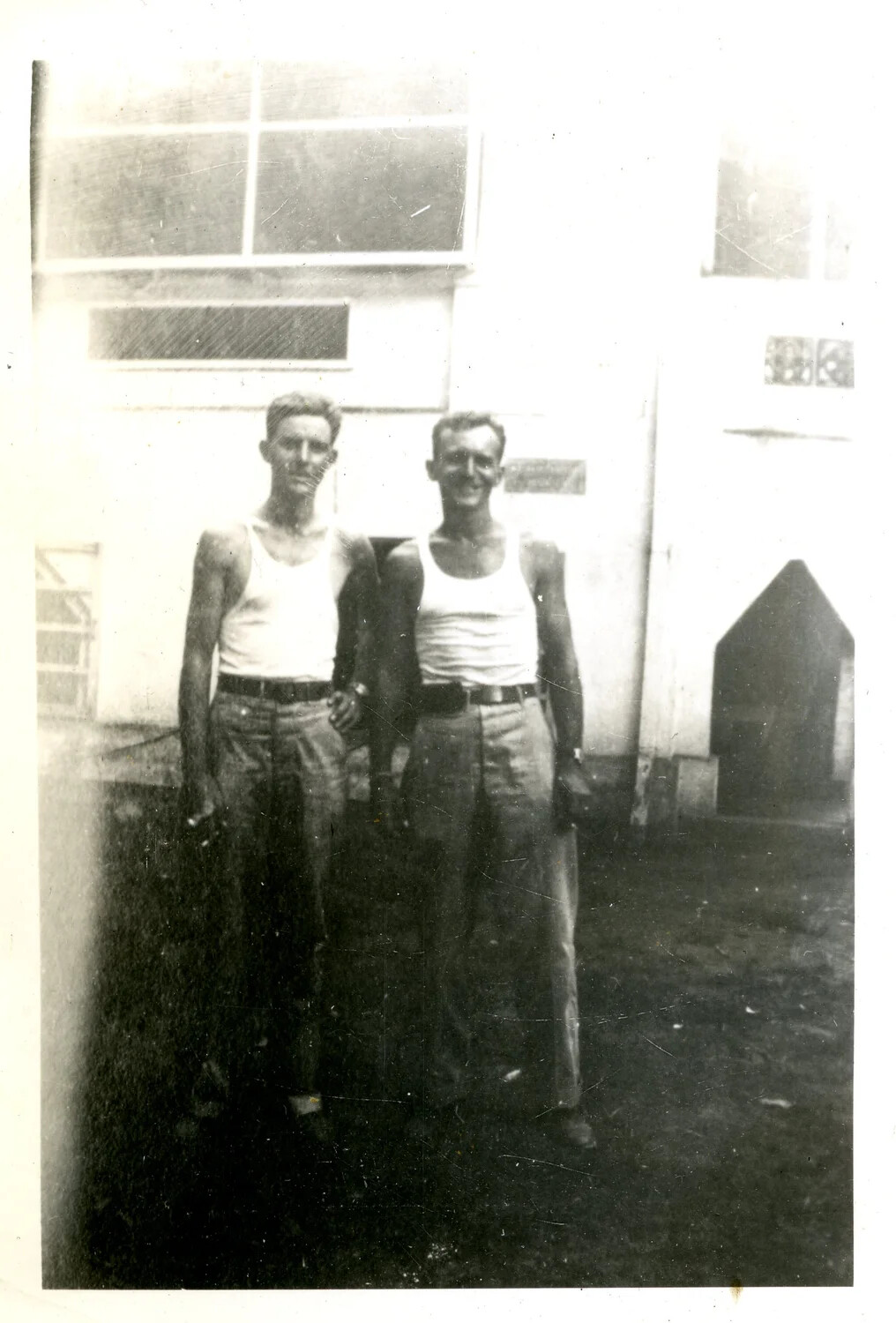 Two Servicemen in Undershirts Posing Outside Base Building
