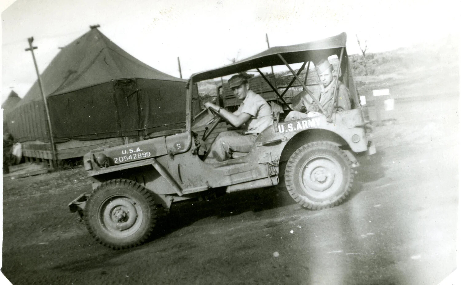 U.S. Army Jeep with Two Servicemen Passing Camp Tents, Pacific Theater, WWII